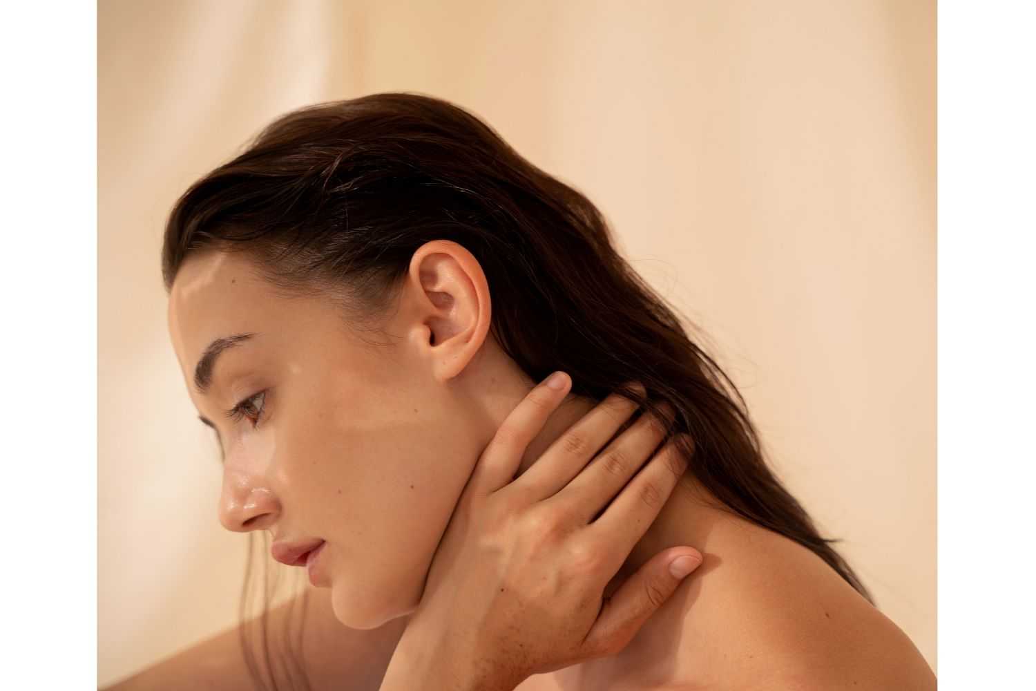 Woman touching neck, deep in thought.